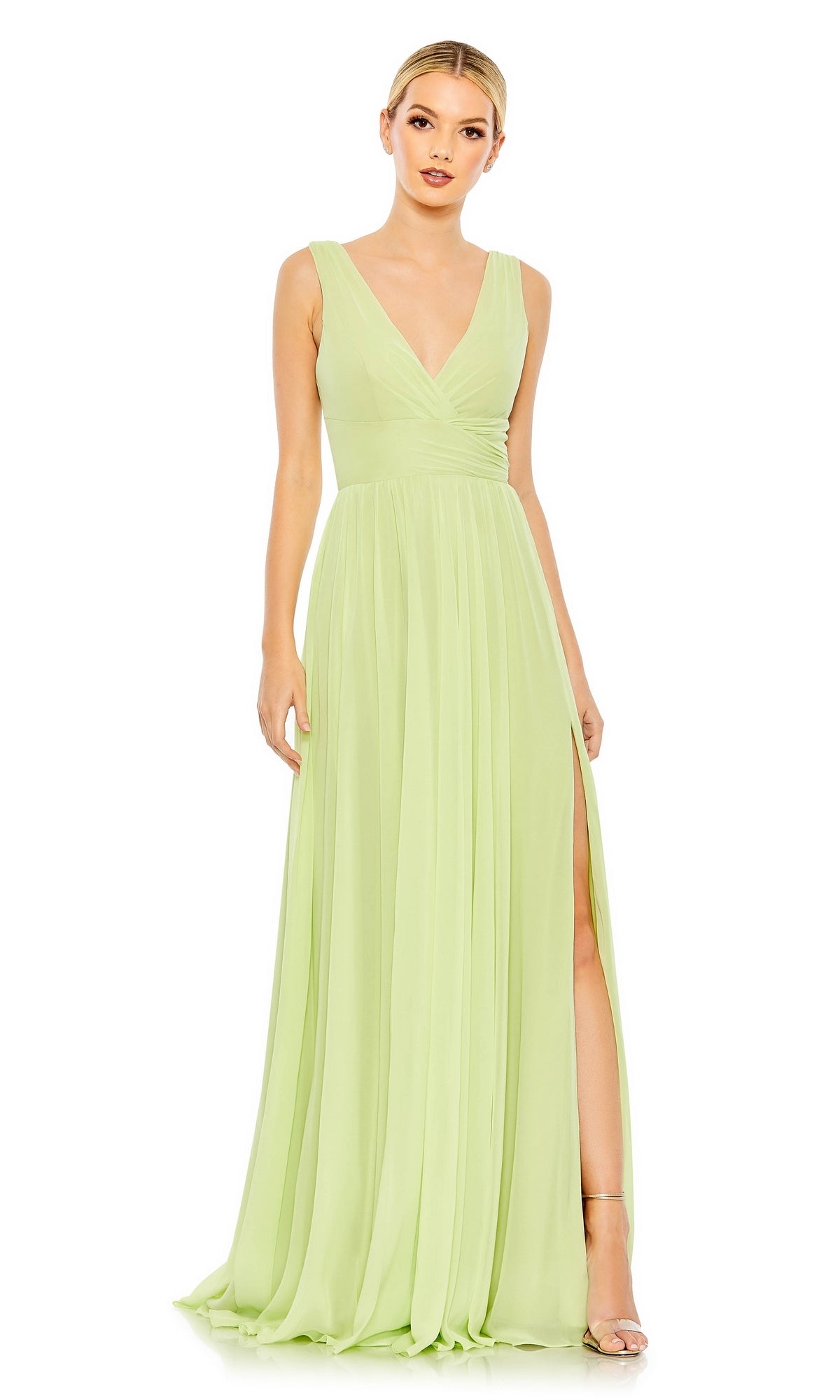 A woman wears the Lime Green Long A-Line Prom Dress with Slit 55793, featuring a sleeveless V-neck and high slit. The floor-length formal gown flatters her silhouette for an elegant look, paired with open-toe heels.